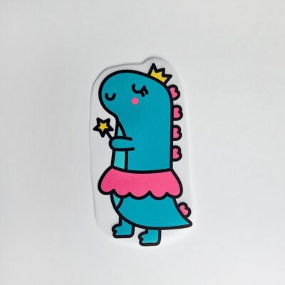 Textiltryck med Turkos dinosaurie med gul krona, rosa kjol och trollstav med en gul stjärna.