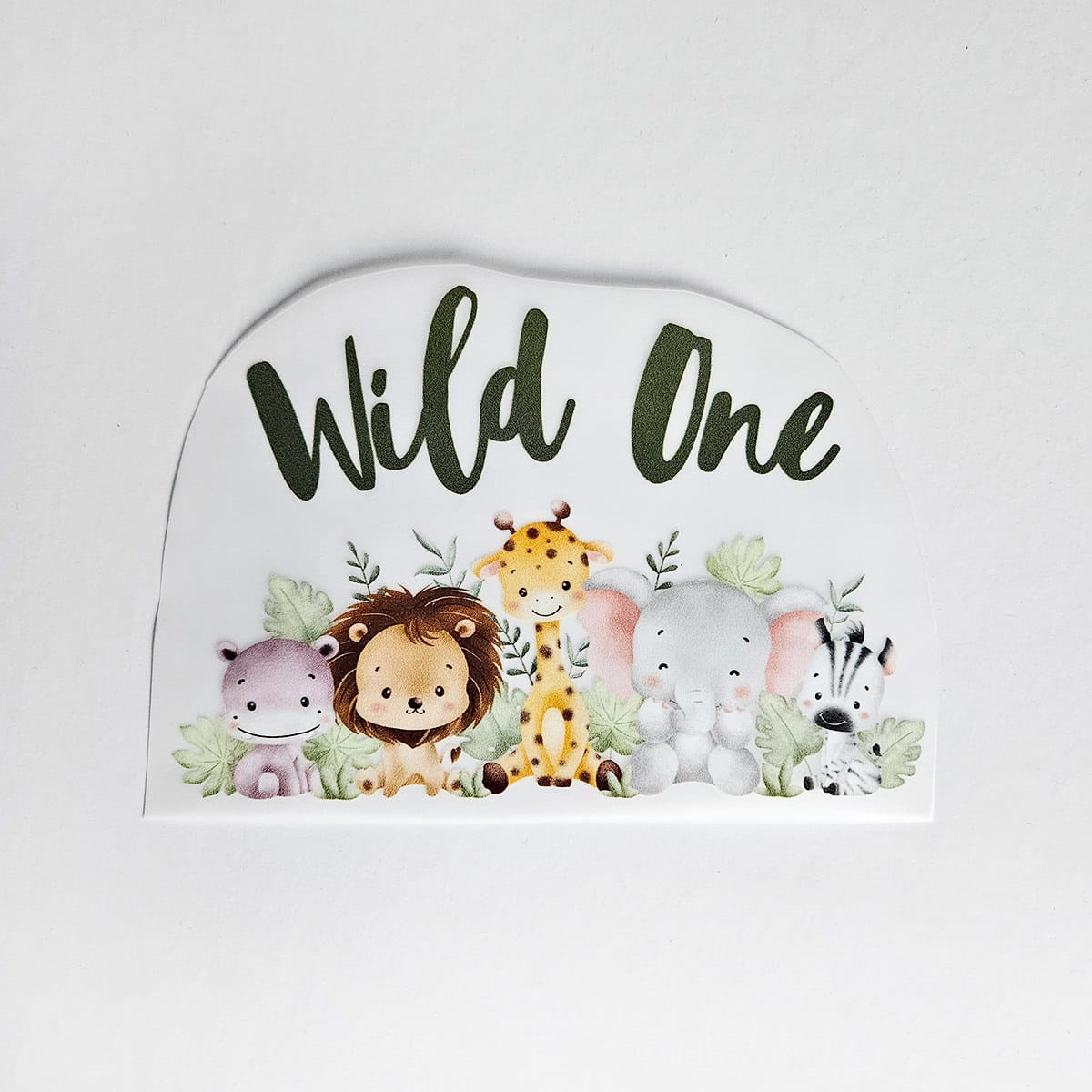 Textiltryck med texten ”Wild One” och djungeldjur i akvarellstil.